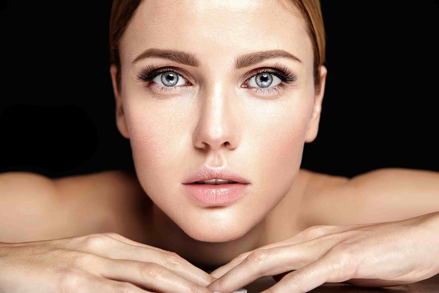 Rosto feminino com maquilhagem natural e pele luminosa, num retrato de beleza elegante e intemporal