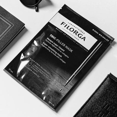 Filorga Time-Filler Mask, máscara facial preta em fibra e saqueta preta de 20 ml.